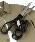 Angled side view of professional laser-guided fabric scissors with ergonomic black handle and long steel blades