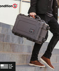 Person carrying a 22 Inch Large Rolling Lockable Beefy Hard Storage Case With Padded Divider And Lid Organizer Model 300 Waterproof Protective Box For Camera And Production Gear Made In USA Black on stairs.