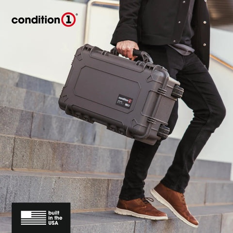 Person carrying a 22 Inch Large Rolling Lockable Beefy Hard Storage Case With Padded Divider And Lid Organizer Model 300 Waterproof Protective Box For Camera And Production Gear Made In USA Black on stairs.