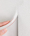 Level Up Your Walls With Thermal Insulated Peel And Stick Wallpaper Self Adhesive Xpe Foam Panels For Heat Blocking Noise Dampening And Easy Decor That Truly Hits Different, close-up of hand peeling back the self-adhesive XPE foam panel.