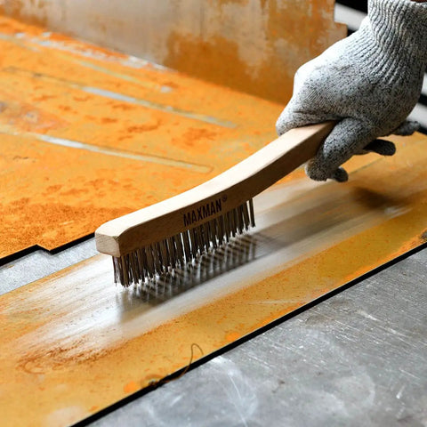 Heavy Duty Wire Brush Set With 14 Inch Beech Wood Handles For Beating Rust And Paint Removal, Grill Cleaning, Welding Slag And Tough Metal Cleanup, Carbon Steel And Stainless Bristle Brushes, 2 Pack in use on rusty metal surface.
