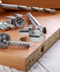 Close-up of 20 Pack Zinc Alloy Shelf Pins With Rock Solid Grip And Easy Install, showcasing silver pegs on wooden board.
