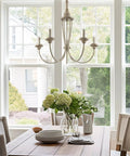 5-Light French Country Chandelier With Adjustable Height In Smoked Cedar And Rustic Metal Finish hanging over dining table.