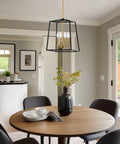 16 Inch 4 Light Modern Black Lantern Pendant Light With Warm Brass Accents in dining room over round table with chairs