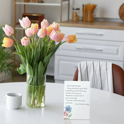 Floral card from the 100 Piece Floral Blank Note Cards Set, 4 by 6 Inches, on a table with tulips in a vase.