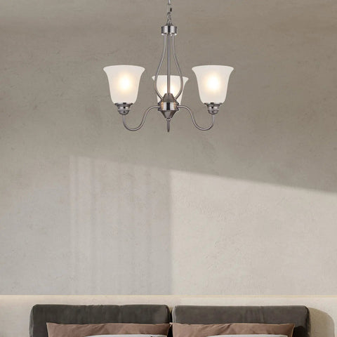 Lit Three Light Chandelier In Brushed Nickel With Frosted Glass Shades above a modern living room sofa