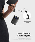Ultra Compact 20000mAh Power Bank Featuring Dual USB Cables And Secure Lanyard Offers Beast Mode 22.5W Fast Charging, held with detachable lanyard.