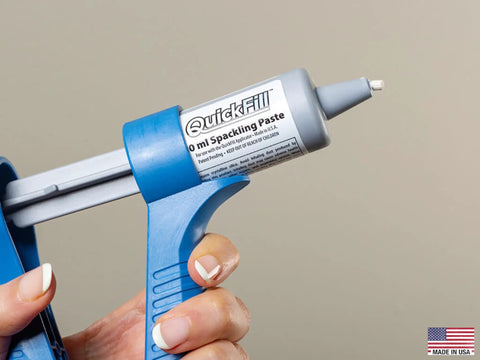 Hand holding Drywall Repair Kit With Built In Spatula Tool And Two 20ml Spackling Paste Cartridges To Fill Nail Holes And Cracks