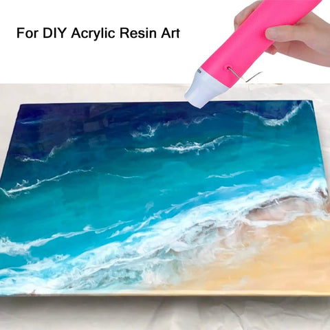 Bubble Removing Heat Gun For Epoxy Resin And Acrylic Art Crafts in use on a blue and sand-colored resin artwork, pink tool.