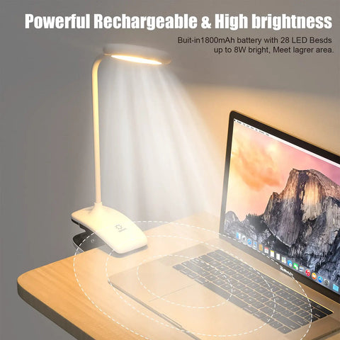 Clip On LED Desk Lamp With Battery Power Cordless Bedside Light shining over a wooden desk and laptop in dim setting