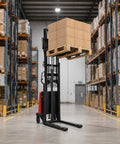 Heavy Hitting Electric Walkie Pallet Stacker With Strong 1.6 Kw Motor Plus Steel Frame Boasting Two Thousand Two Hundred Four Pound Capacity And Ninety Eight Inch Lift Height For Dock To Rack Yard Work lifting a pallet of boxes in a warehouse.
