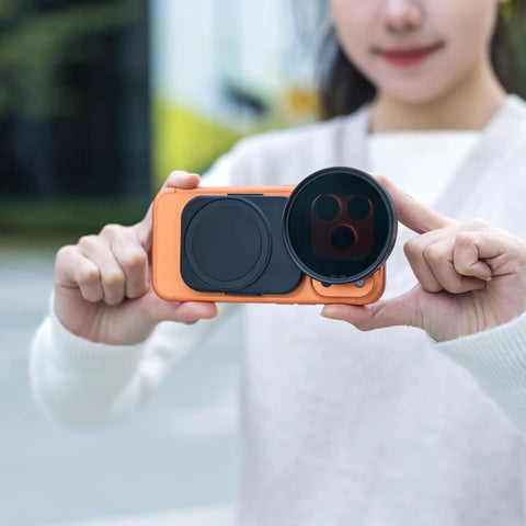 Person holding 67mm Magnetic Double Sided Phone Lens Filter Adapter Mount With Cold Shoe for iPhone in use outdoors