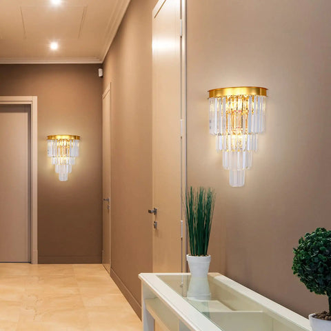 Gold Crystal Wall Sconce Lighting Fixture With Four Tier K9 Crystals in hallway, warm glow illuminating wall and plants