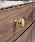 Close-up of a cabinet with a champagne bronze knob, part of 10 Pack Cabinet Knobs In Champagne Bronze Heavy Duty Zinc Alloy Hardware Handles For Kitchen Cabinets Bedrooms Dressers And Wardrobes Easy Install Durable Finish Classic Look For Any Home.