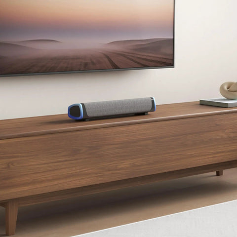 R30 USB Powered Computer Speakers with Colorful LED Lights and 3.5mm Aux surround soundbar on wooden table under TV.