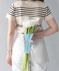 Woman holding bouquet wrapped in Disposable OPP Flower Sleeve Bags for Bouquets 150 Pack Clear Floral Packaging Wrap