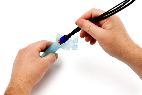 Hands assembling Direct Burial Splice Kit DBO B 6 Bulk For 18 To 12 AWG Wire with UV resistant insulation and steel spring.
