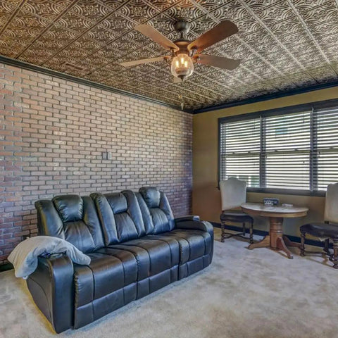 Room with copper faux tin PVC ceiling tiles 2x2 glue up, paintable tin look for quick DIY makeover, installed in a living area.
