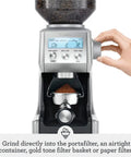 Hand adjusting grind settings on Smart Grinder Pro Coffee Grinder With 60 Settings For Espresso And Brew Dope Dose Control Digital Timer.