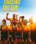 Group of cyclists in yellow-orange jerseys at sunset, celebrating with text "Chasing The Sun" promoting New Summer Release Chasing The Sun Delivers A Dope Feel Good Road Trip Anthem With Bright Melodies, Sunny Beats, And Party Vibes For City Nights, Premiering June 1 2025, Stream Now Or Download For Your Ultimate Sunlit Playlist.