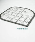 Clear Acrylic Quilting Ruler With Templates And Curved Corner Cutter, 6x6 inches, black edges, showing thickness of 3mm.
