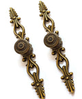 Two vintage bronze cabinet handles with flower pattern and ergonomic grips. Part of the Vintage Bronze Patina Finish Cabinet Hardware Set Of 10.