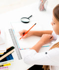 Workhorse Stainless Steel Ruler With Non Slip Cork Back Dual Inches And Centimeters Scale next to student writing on desk