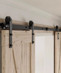 Installed heavy duty sliding barn door hardware kit for 60 inch wide double doors, 20 foot track, black finish, I shaped hangers.