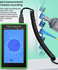 Green Fiber Inspector handheld video probe with a 5-inch touchscreen, connected to a fiber optic probe and blue adapters.