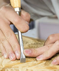 Close-up of a hand using a Six Piece Wood Carving Tools And Kickass CRV Steel Chisel Set With Rust Resistant Coating And Fishtail V Gouge Design For Fine Woodworking Where Clean Cuts Truly Deliver The Goods On Every Detailing Project Today.