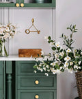 Room with green cabinet drawers featuring Two Pack Matte Gold Bifold Closet Door Knobs, Round Cabinet and Drawer Knobs for Wardrobe, Dresser.