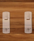 Two white self-locking shelf pegs on wooden surface, part of 50 Pack Self Locking Shelf Pegs For Cabinets And Shelves, White Plastic Pins
