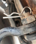Close-up of R Clip Hairpin Style Cotter Pin securing metal components on trailer hitch, heavy-duty steel wave shape clip