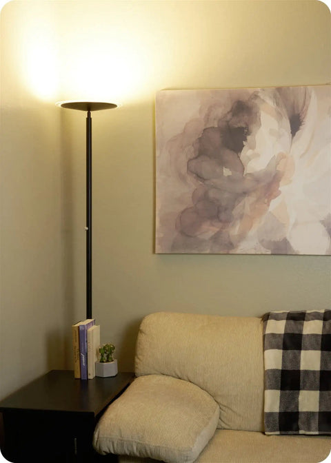 70 Inch Modern LED Torchiere Floor Lamp with Glass Diffuser beside sofa, lit, matte black finish, in living room corner