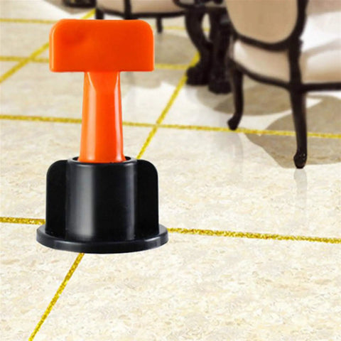 Ultimate Tile Leveling System Kit For Ceramic Floor And Wall Tiles, Reusable Dowels With Wrench, 100 Pcs Flat Pin Fasteners, Keeps Grout Even And Tiles Flat, Speeds Up Installation For DIY Or Pros. Orange tile leveling wedge in black base on ceramic floor