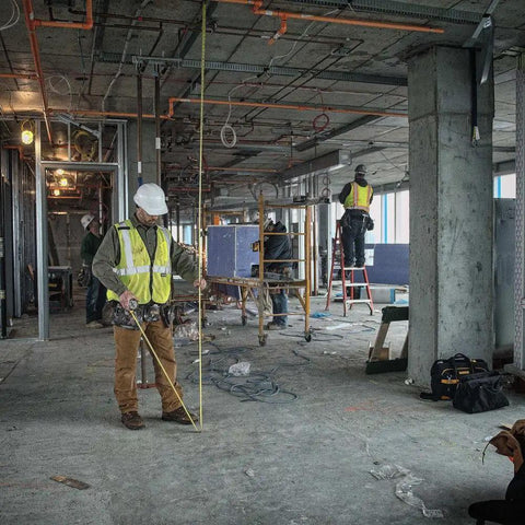 Construction worker using NGT 25 Foot Tape Measure With One And A Quarter Inch Tape For Quick Accurate Measurements on site