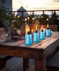 4 Pack Glass Table Top Torches With Wick And Cap, Multicolor Citronella Lanterns For Outdoor Yard Patio Deck Garden displayed on a table