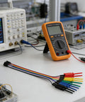 Micro SMD Grabber Clips for Logic Analyzer and Oscilloscope Probes on lab bench with multimeter and electronics equipment.