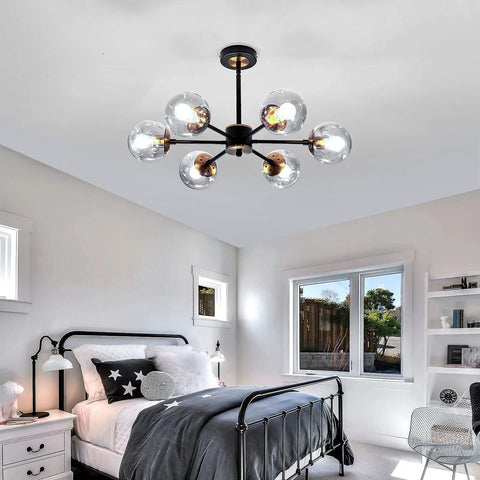 Lit Six Light Black Glass Globe Chandelier in bedroom, modern ceiling pendant lighting fixture with smoke gray glass globes.