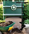 Easy To Use Outdoor Compost Aerator Tool For Manual Turning And Stirring Rotating Aerator shown next to a compost bin.