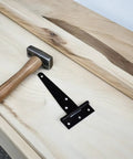 8 Pack Galvanized Zinc Alloy T Strap Door Hinges With Heavy Duty Stable T Shape Design And Triangular Support placed on wood