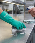 Person cleaning stainless steel surface wearing Heavy Duty Nitrile Glove Set, 15 Mil Chemical-Resistant, 13 Inch Gauntlet With Bisque Grip