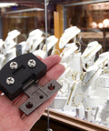 Heavy Duty Stainless Steel Glass Door Hinge For Tempered Glass Doors With Smooth Operation held in hand near jewelry display