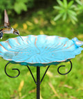 34 Inch Tall Metal Bird Bath On A Stake For Outdoors with a turquoise base, viewed with a hummingbird, in a garden setting.