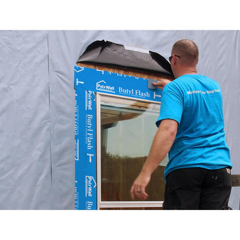 Man applying Beefy Butyl Window Flashing Tape 4 Inch By 100 Foot Waterproof Self Adhering Self Sealing Weatherproof Sealant to window frame