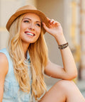 Totally Fire Leather Wrap Bracelet For Women Featuring Super Comfy Braided Leather Straps And Mixed Brown Beads With A Boho Western Layered Cuff Look That Gets Compliments Every Single Day worn by a smiling woman in a straw hat.