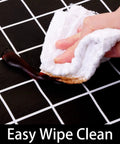 Close-up of Waterproof Elastic Fitted Vinyl Table Cover 30x72 With Flannel Backing, being wiped clean, demonstrating stain resistance.