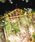 300 LED Curtain String Lights With Remote Control, Warm White Indoor Outdoor Decor illuminating a garden setting