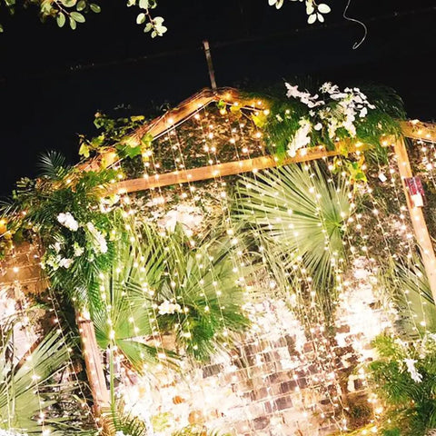 300 LED Curtain String Lights With Remote Control, Warm White Indoor Outdoor Decor illuminating a garden setting