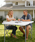 Couple playing cards outdoors on 34-Inch Square Folding Table With Carrying Handle For Indoor Outdoor Picnics Parties Fold-In-Half Design